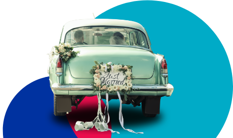 Classic car with bride and groom inside with flowers and just married on the back