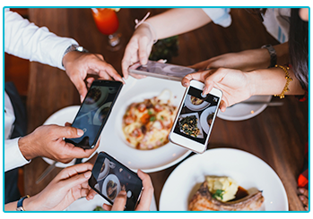How to get amazing shots for Instagram on your phone! - Four people photograph their food.