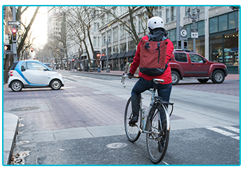 Stay safe while cycling to work - cyclist in red jacket