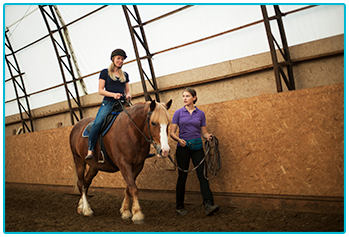 Am I too old to learn to ride a horse? - Instructor leading student indoors