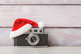 a small vintage camera wearing a santa hat