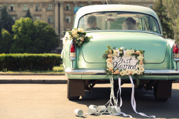 the rear of a vintage wedding car with flowers and a just married sign