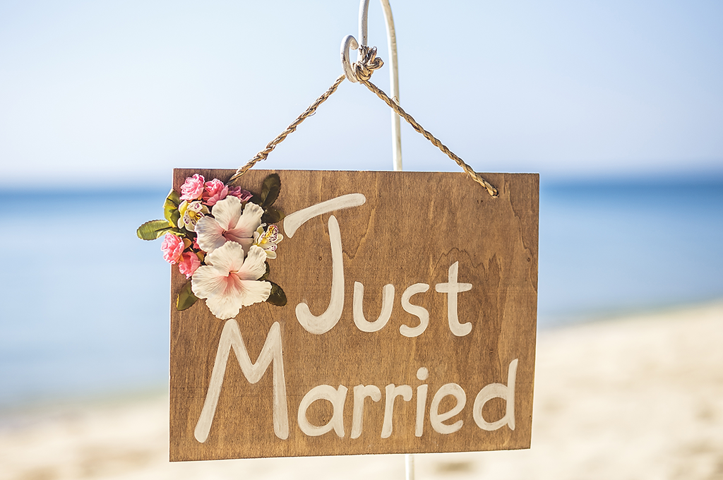 a wooden sign with just married painted on it