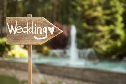 wooden sign pointing the way to the wedding