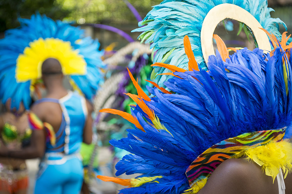 a group of dancers wearing colourful feathered costumes at a street carnival