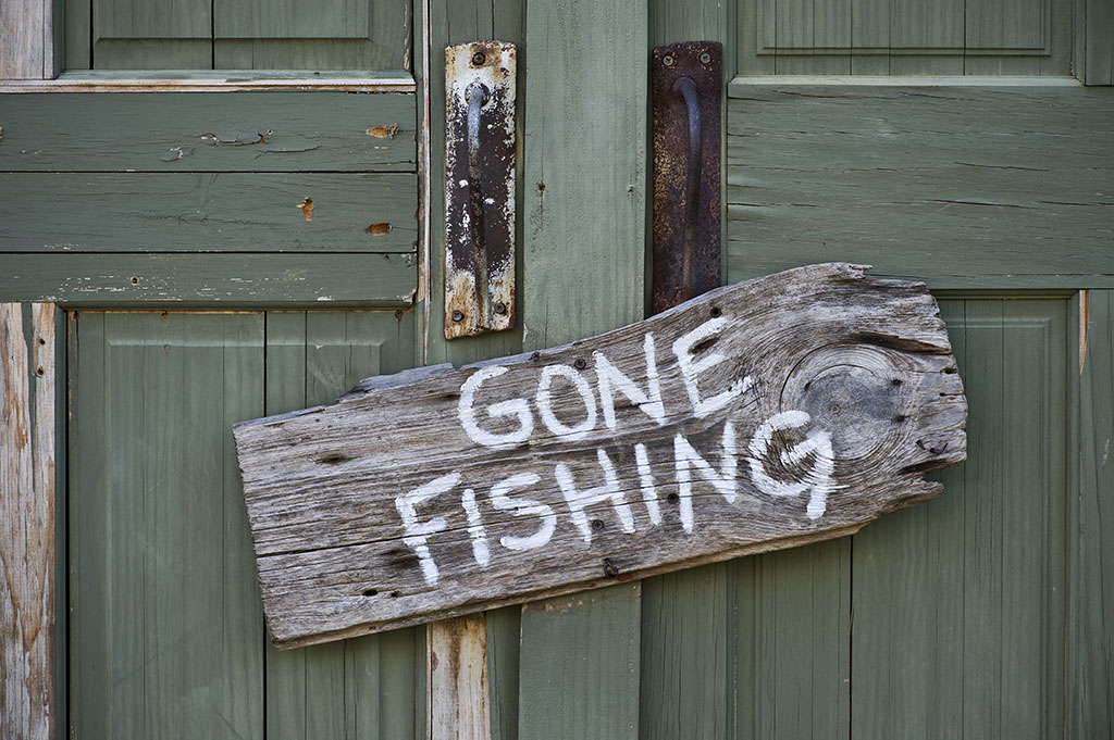 "gone fishing" sign stapled to the door
