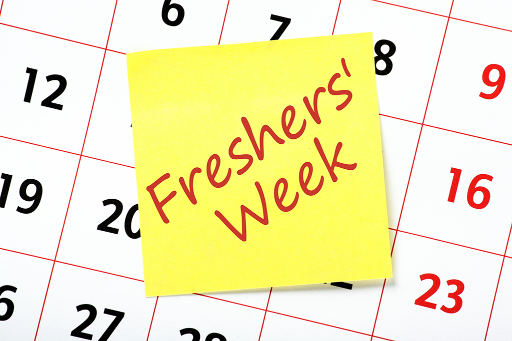 a freshers week posit note on a top of a calendar 