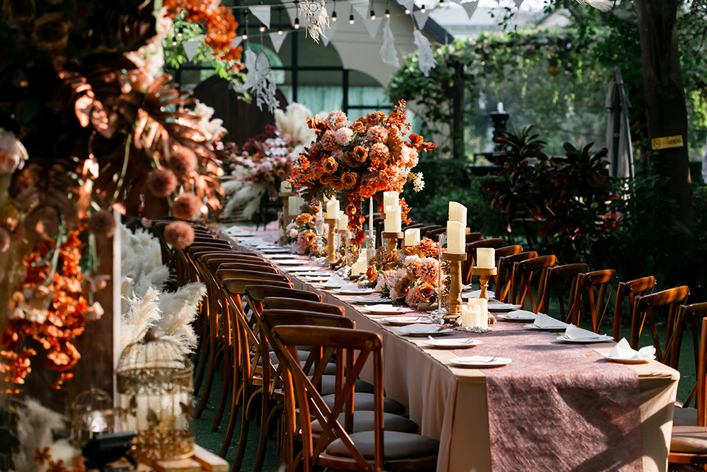 A long table with flower and candle centrepieces at a wedding venue ready for guest 