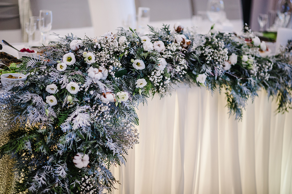 a winter wedding decor idea, frosty leaf and white flower table decoration 