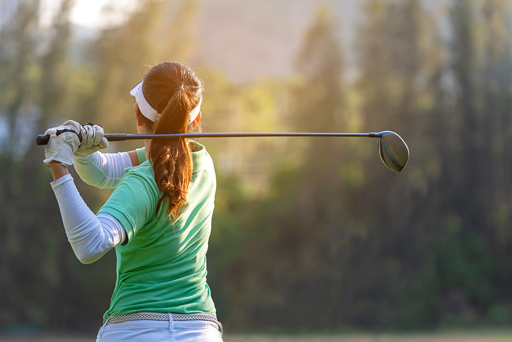 female golfer swinging a golf club