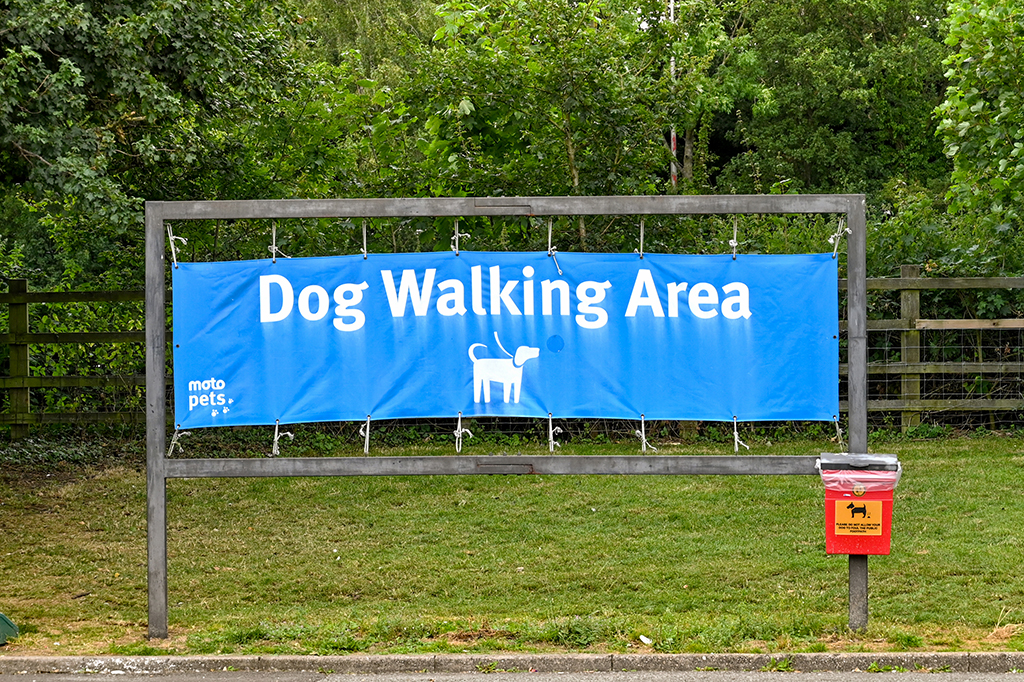 Swindon, England - august 2021: Sign marking a designated exercise area for dog walking at the motorway service station at Leigh Delamere.