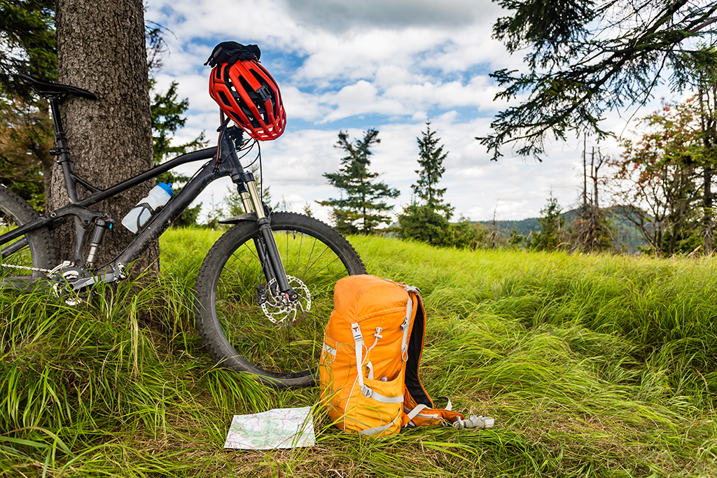 Mountain biking equipment in the woods, bikepacking adventure trip in green mountains. Travel campsite and MTB cycling with backpack, wilderness forest in Poland.
