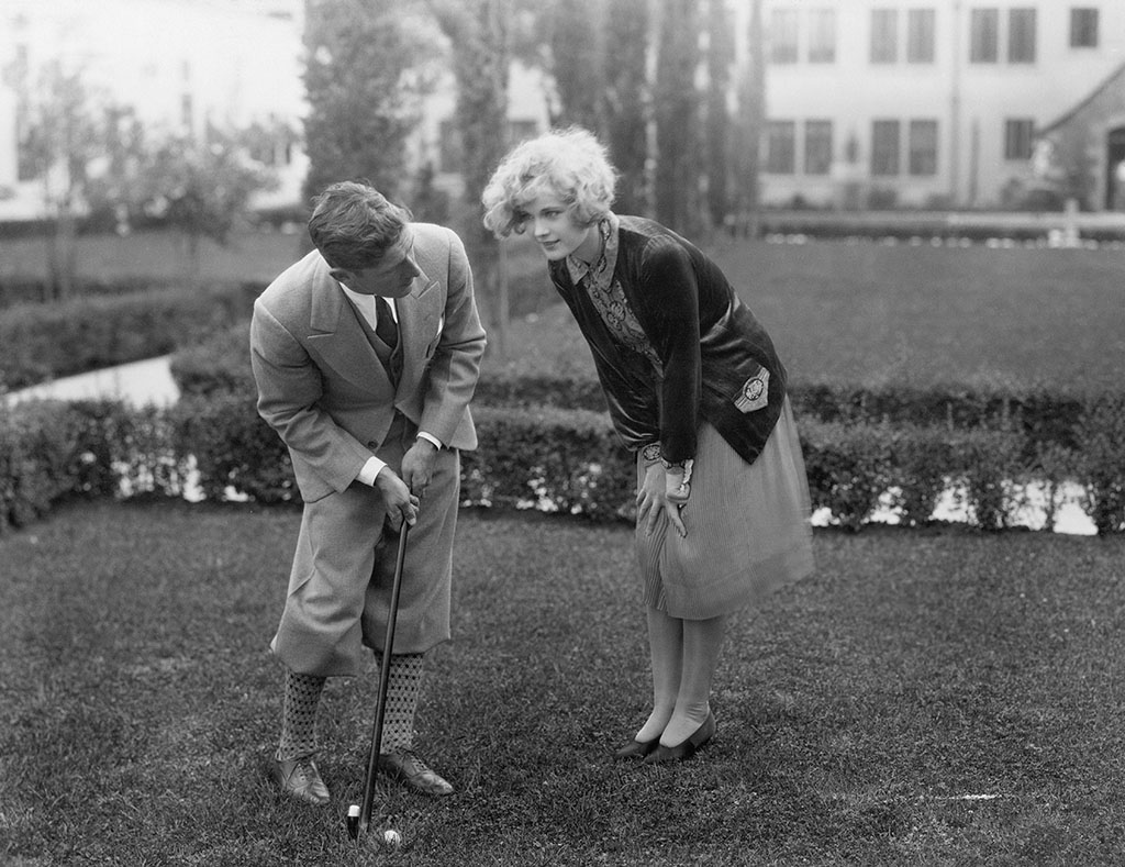 best golf brands man talking to woman while golfing.