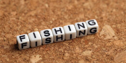 Fishing word of plastic cube concept on wooden background.