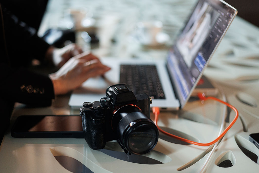 Professional Photographers Insurance Workspace With Laptop And Camera.